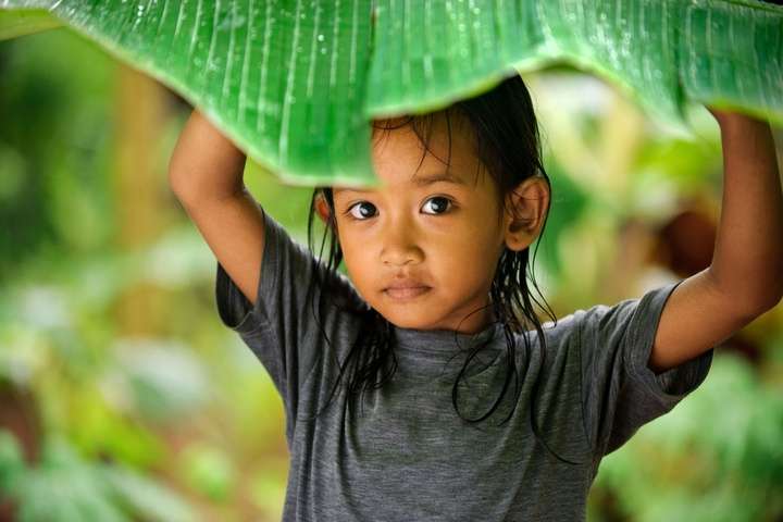 Meisje aan het schuilen voor de tropisch regen