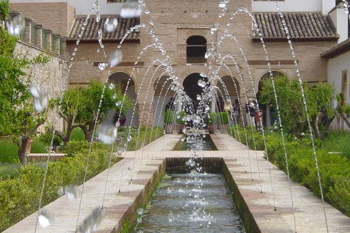 Eén van de tuinen van het Alhambra Paleis met zuilengangen, vijvers, fonteinen en heerlijke geurende rozen