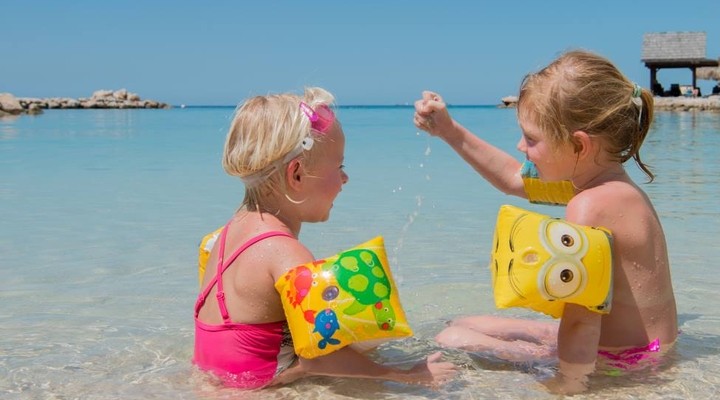 Kinderen spelen op het strand van LionsDive Resort