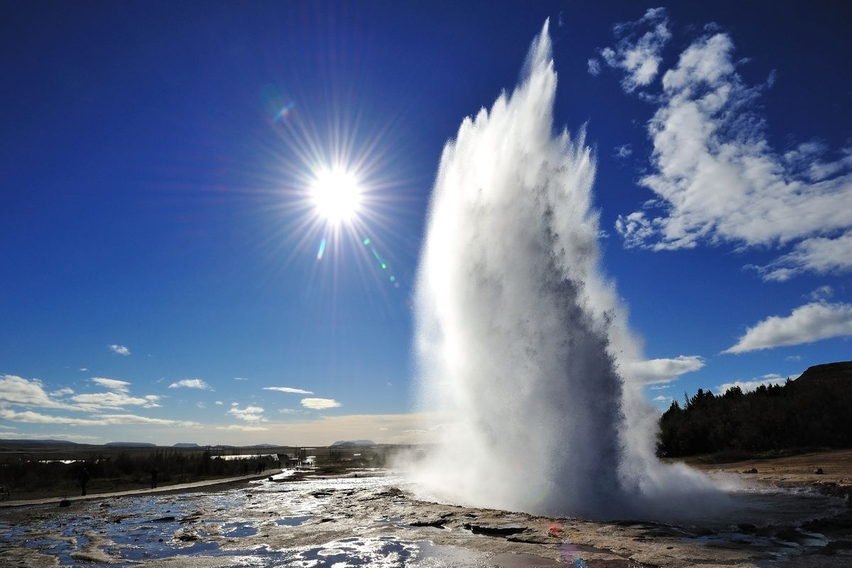Uitbarsting Strokkur geiser met op de achtergrond het zonnetje