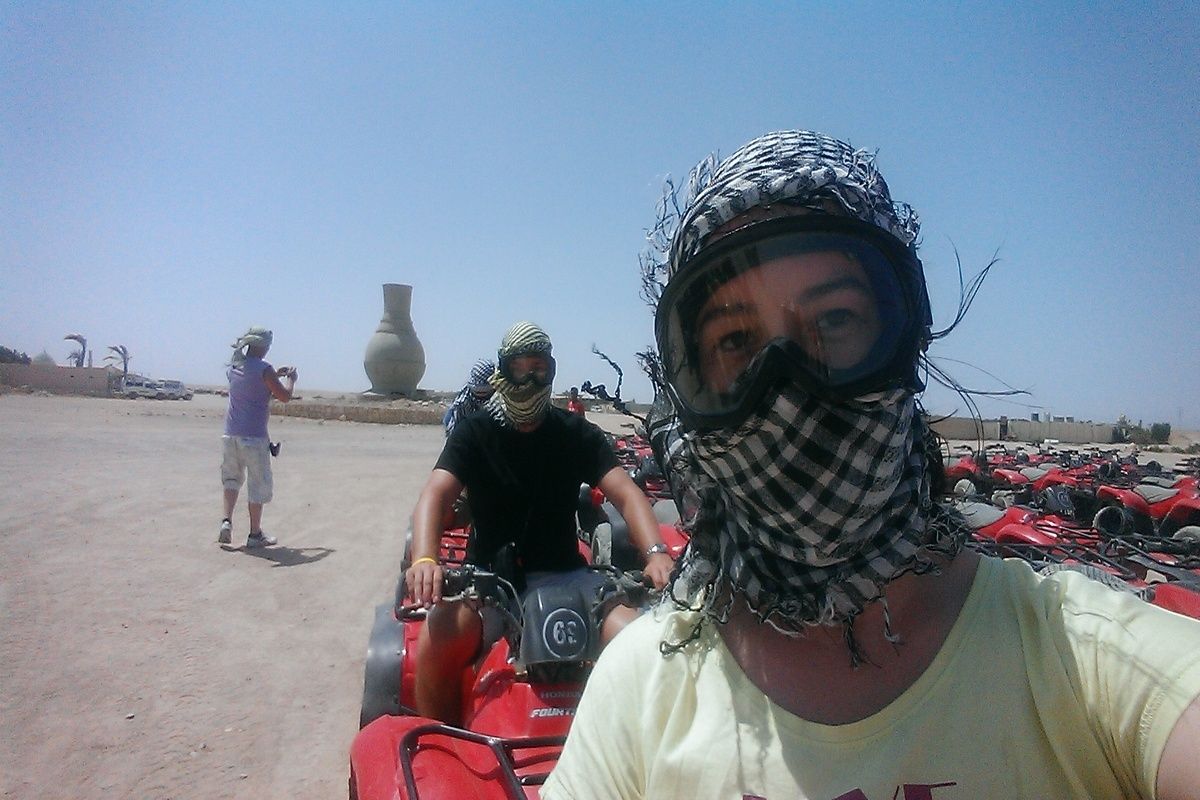 Met een sjaal omgebonden en een stevige bril op quad rijden in de woenstijn