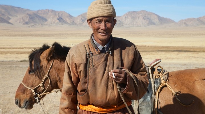 Nomade met paard in de steppen van Mongolie
