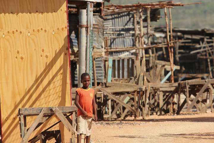 Jamaicaanse jongen in verwoeste wijk