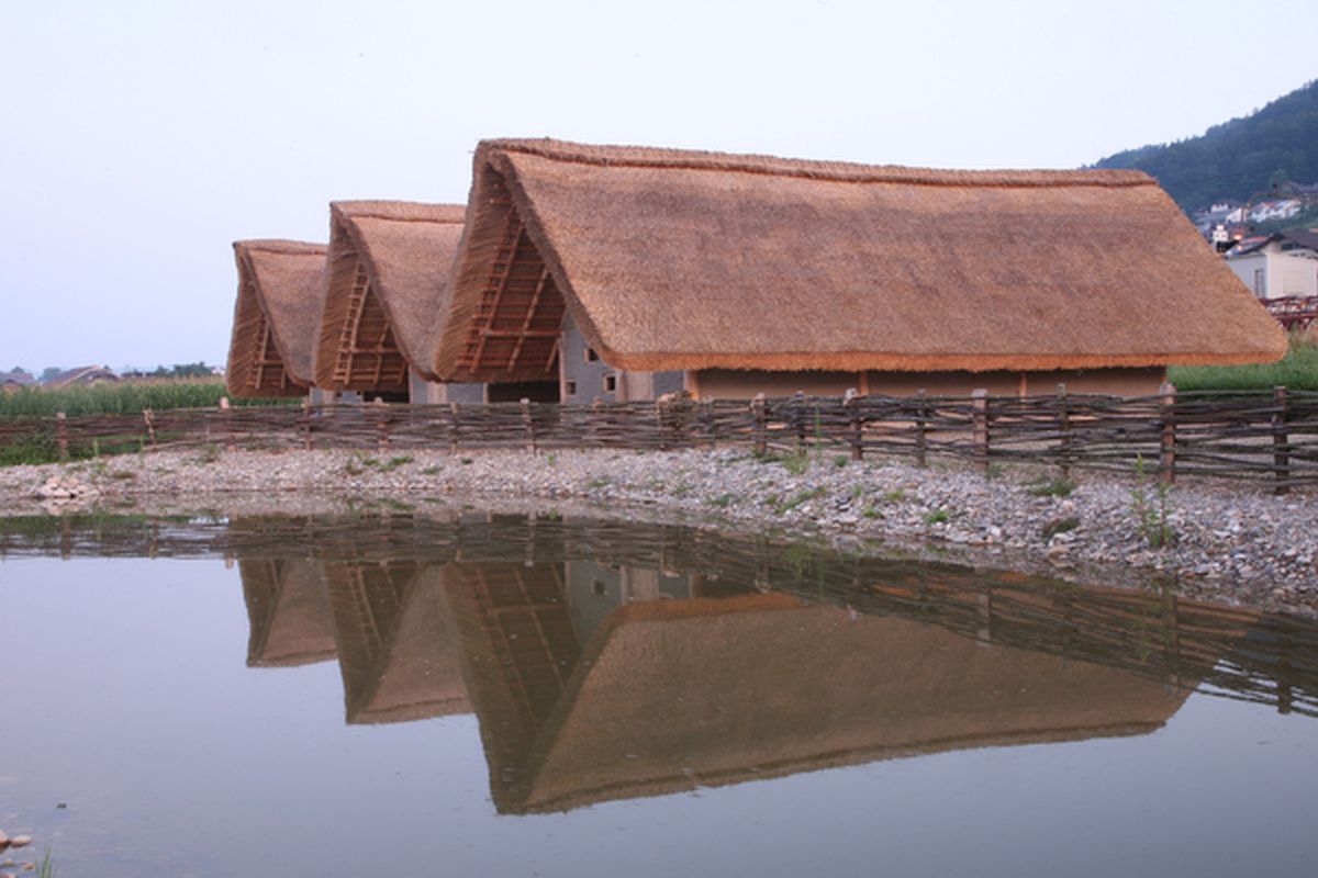 Prehistorische paalwoningen 'Pfahlbausiedlung Wauwil' in de Alpen © pfahlbausiedlung.ch