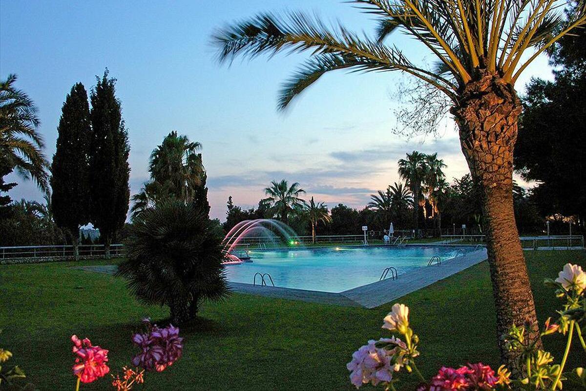 Het zwembad met verlichte fontein op Vilanova Park