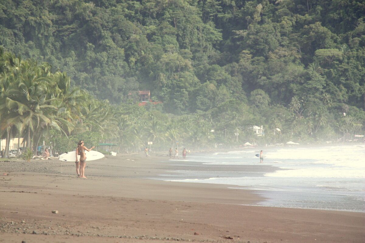 Surfers op het strand bij Jaco