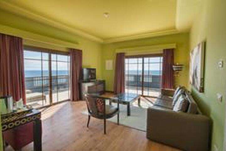 de woonkamer van '2-persoonskamer, Senior Suite Zeezicht'