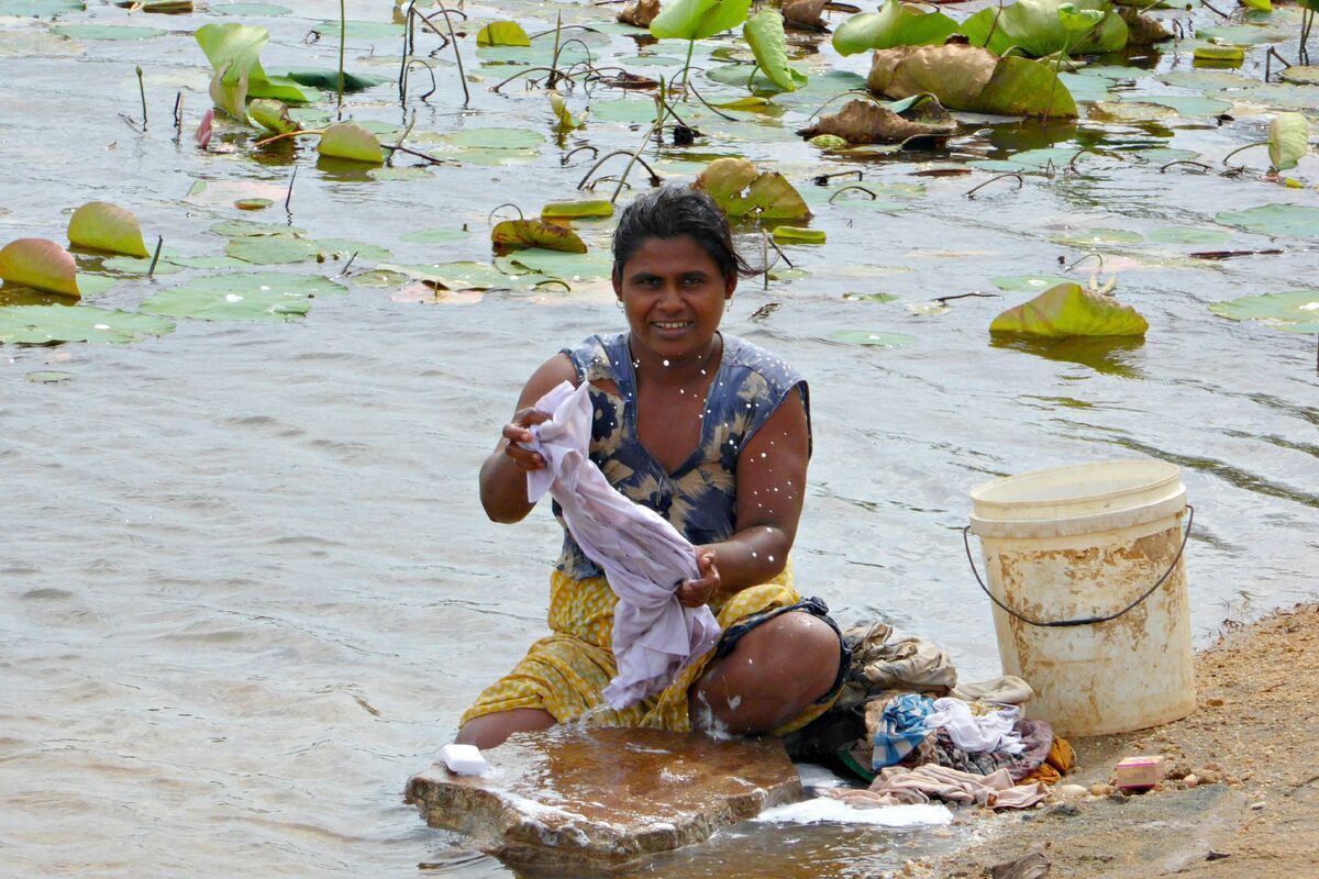 Singalezen wassen hun kleding in de rivier