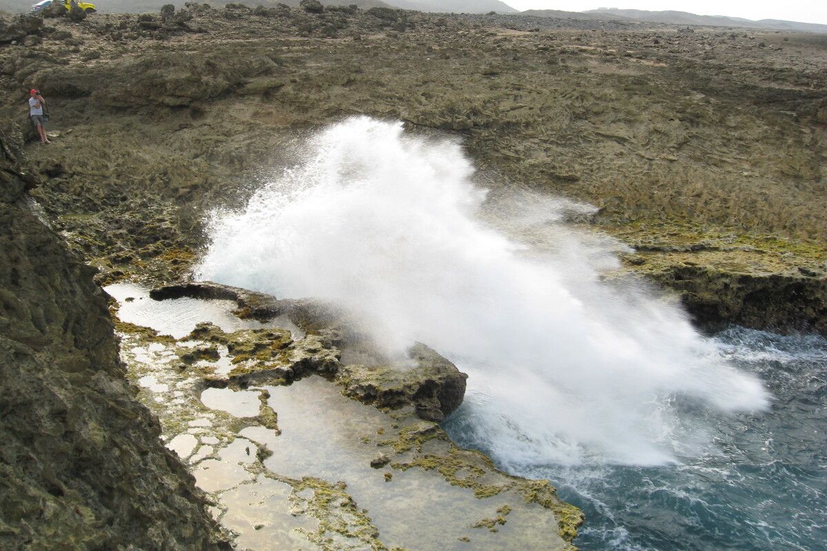 Hoog opspattend water tegen de rotsen