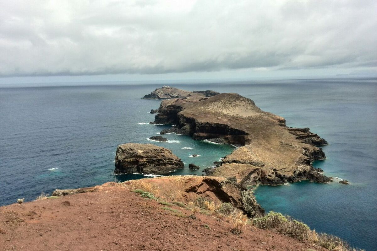 Een lange rots gelegen in de blauwe zee rondom Madeira