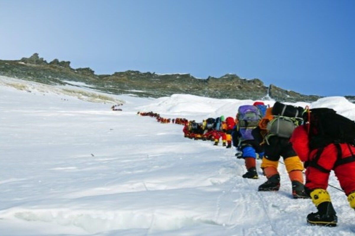 Een meterslange rij van mensen die allemaal de Mount Everest aan het beklimmen zijn