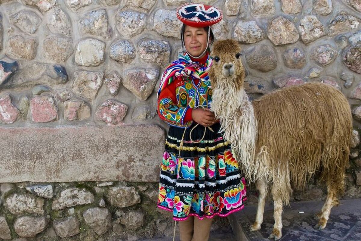 Een Peruaanse vrouw in klederdracht met een alpaca