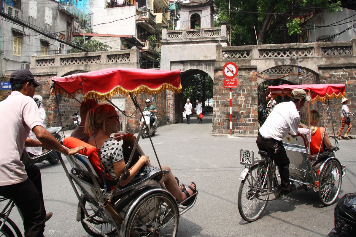 Toeristen maken een rit door de stad met een Riksja