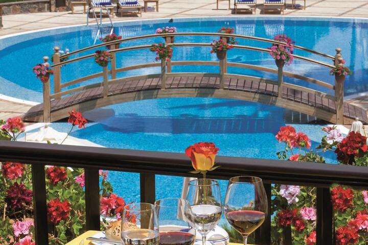 Kleurrijke bloemen rondom het zwembad van Seaside Residencia