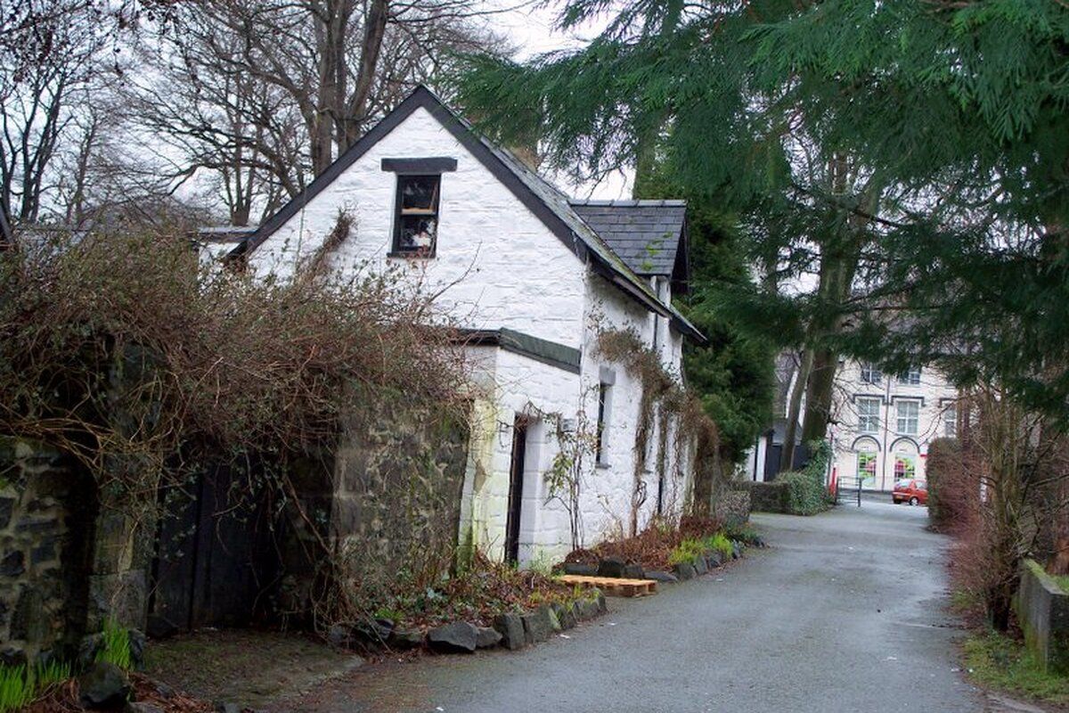 Witte cottage in straat Wales