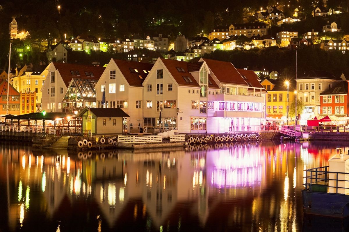 Bergen in de avond met huizen aan het water
