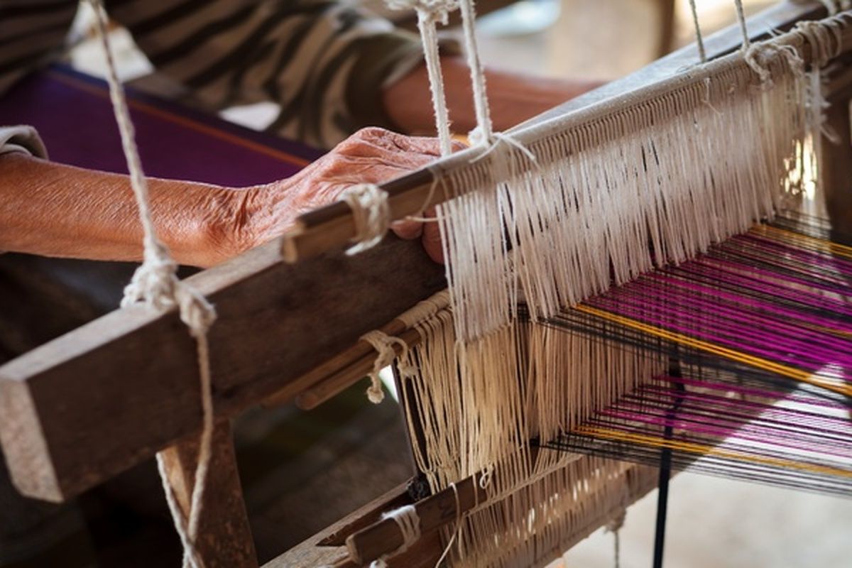 Een arbeider aan het werk op een weefmachine